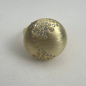 Anillo de plata chapado en oro amarillo media bola matizada con circonitas de varios tamaños engastadas