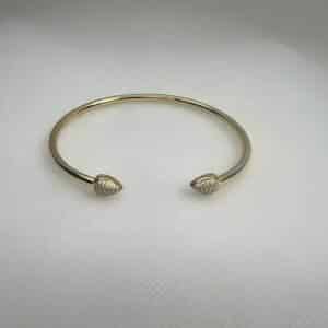 Esclava de plata chapada en oro amarillo abierta en el centro con terminacion en forma de gota con circonitas.
