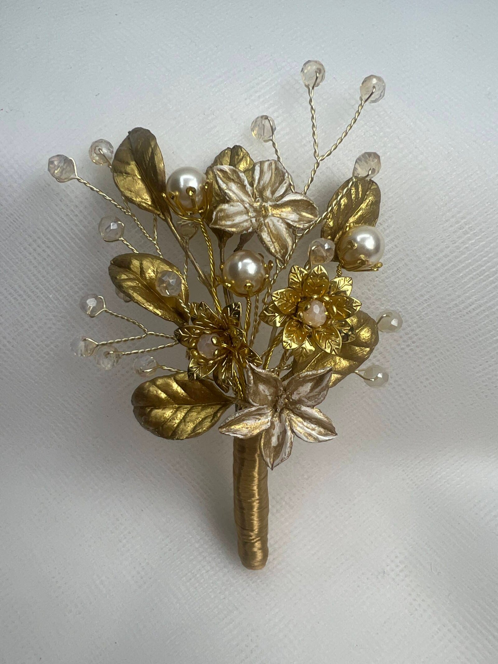 Prendido con flores y hojas de porcelana,cuentas de cristal y flores metalicas.